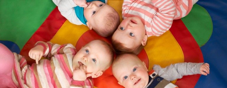Overhead View Of Babies Lying On Mat At Playgroup